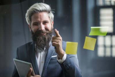 Businessman Holding a Digital Tablet and Gesturing With Sticky Notes in Front